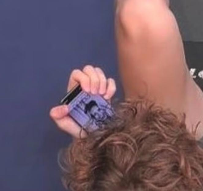 Person holding a small purple card with an image on it.