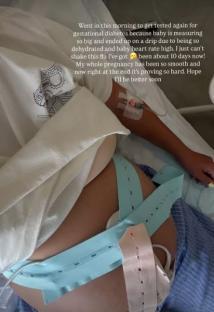 Pregnant person in hospital bed with IV and fetal monitor.