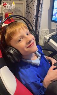Boy wearing headphones and playing video games.