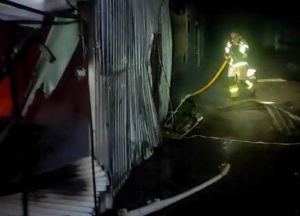 Firefighter extinguishing a fire at a damaged building in Sumy region.