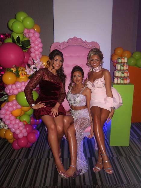 Three young women, including Tyson Fury's daughter Venezuela, pose in front of a pink throne with balloons and cupcakes.
