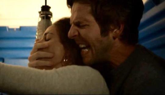 A man covering a woman's mouth with his hand.