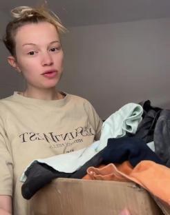 Woman packing clothes into a box.