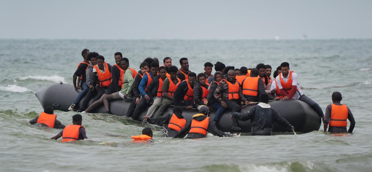 Migrants in a small boat at sea.