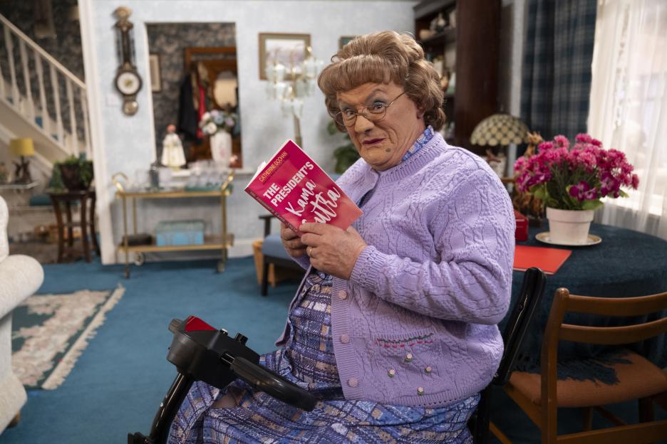Agnes Brown on a mobility scooter reading "The President's Kama Sutra."