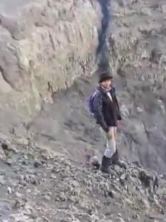 Person standing near the edge of a volcano.