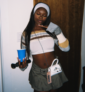 Photo of a young woman in a 90s-inspired outfit.