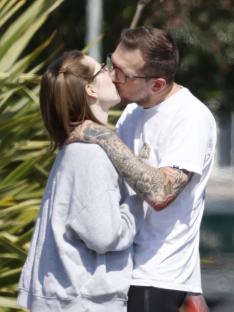 A man and woman kissing on a street.