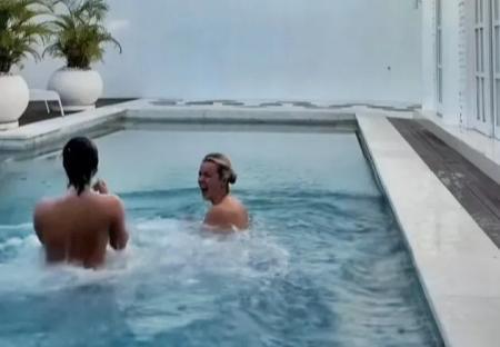 Two women skinny dipping in a shared villa pool.