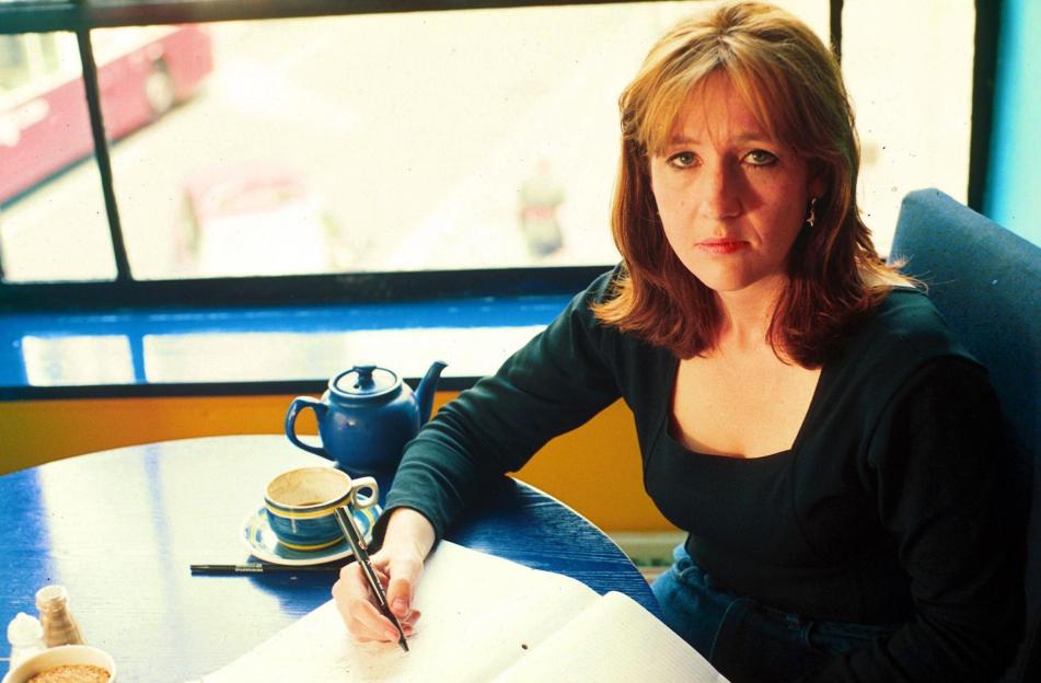 J.K. Rowling writing at a table.