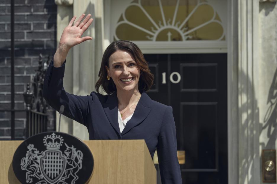 Suranne Jones as Abigail waving from a podium outside 10 Downing Street.
