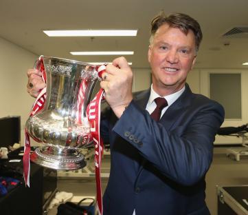 Louis van Gaal holding the FA Cup trophy.