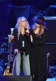 Christina Applegate speaking onstage at a concert.