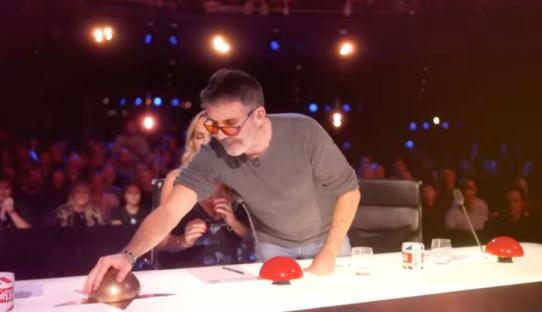 A judge on Britain's Got Talent pressing a golden buzzer.