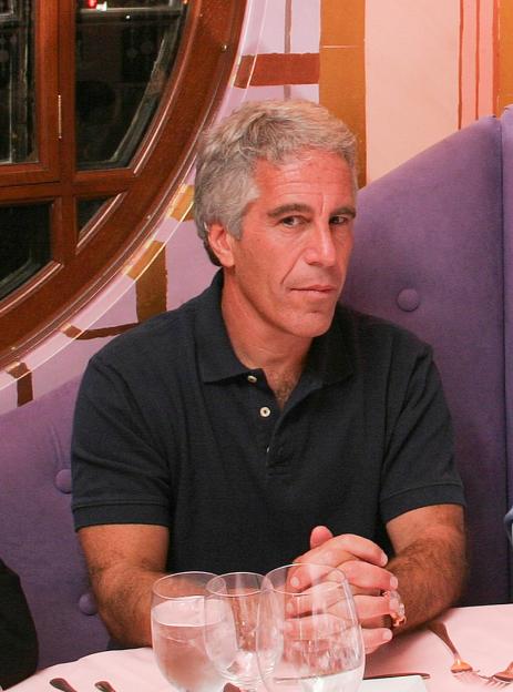 Photo of Jeffrey Epstein sitting at a table.