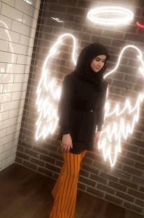 Photo of Aya Hachem in front of angel wings.