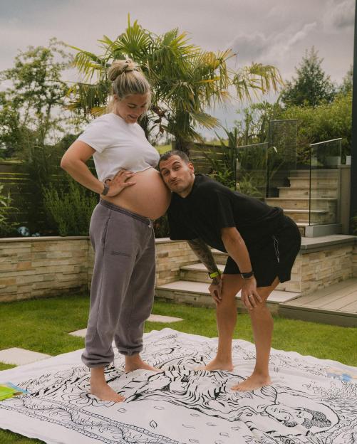 Gemma Atkinson showing her baby bump with Gorka Márquez leaning his head on it.