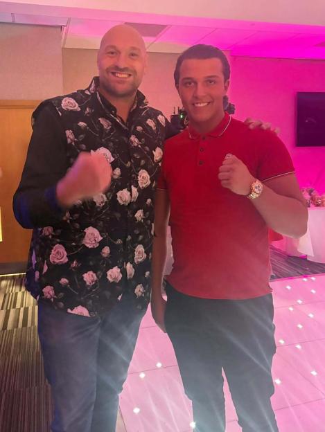 Tyson Fury and his brother Shane Fury smiling with fists raised.
