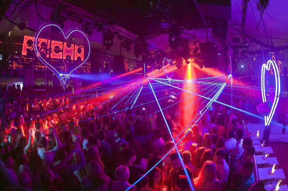 Crowded nightclub dance floor with laser lights.