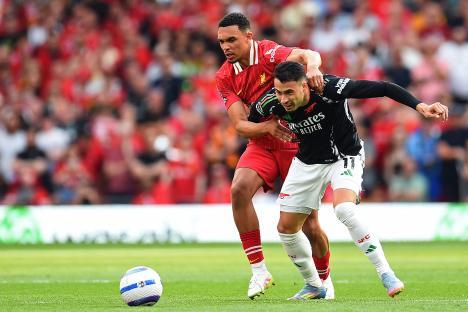 Liverpool's Trent Alexander-Arnold vying with Arsenal's Gabriel Martinelli during a football match.