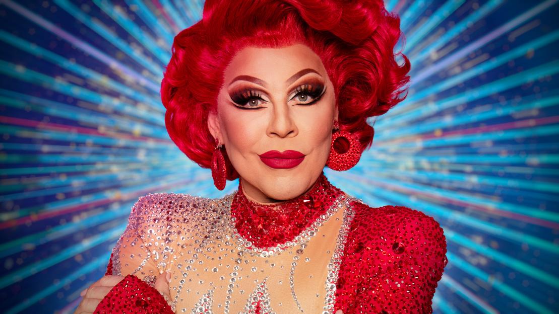 Portrait of a drag queen in a red sequined dress.
