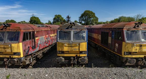 Aerial view of rusty, abandoned diesel locomotives in a quarry.