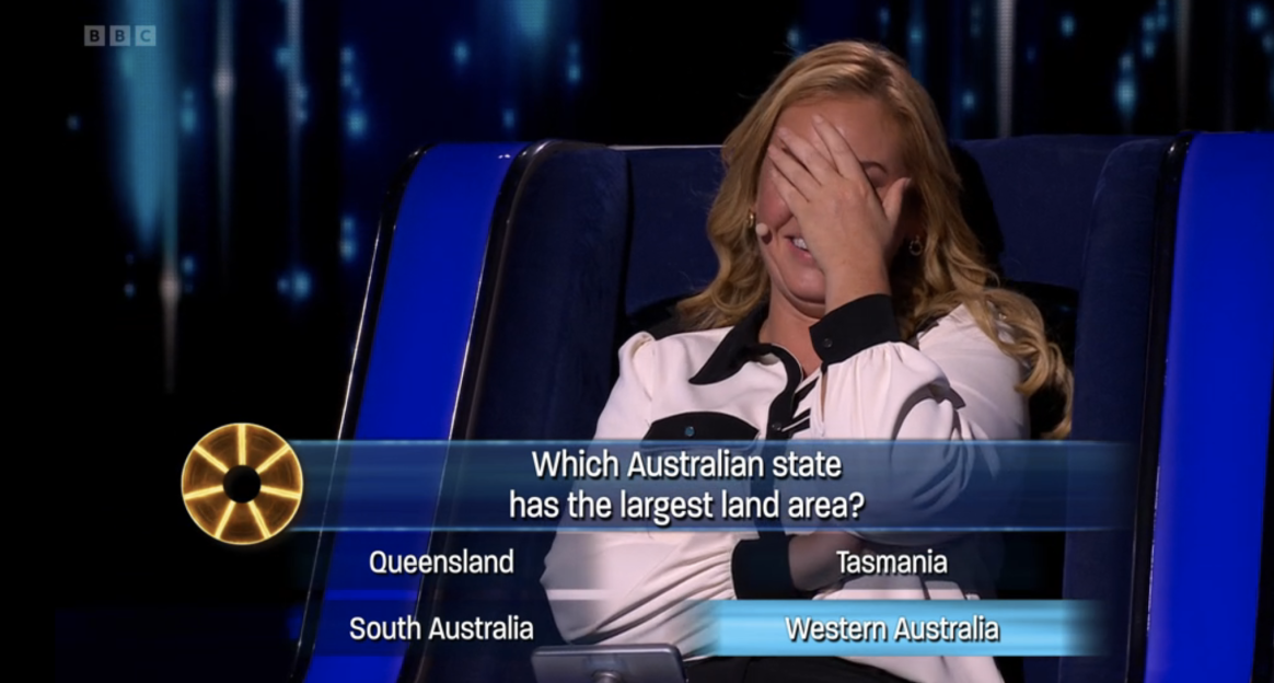 Screenshot of a game show contestant covering her face, with a question about the Australian state with the largest land area displayed on screen.