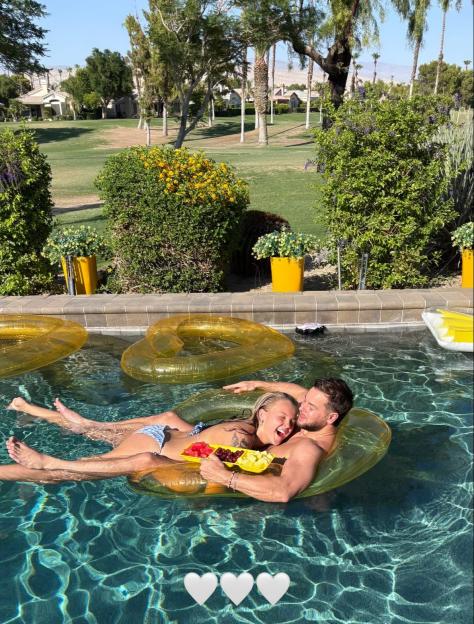 JoJo Siwa and Chris Hughes cuddling in a pool.