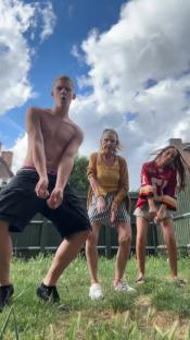 Three people dancing outdoors.