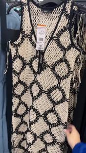 Beige sleeveless dress with black crocheted detail.