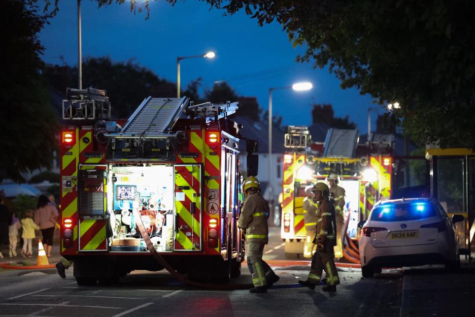 Firefighters at the scene of a fire at night.