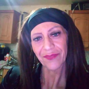 Close-up portrait of a woman with long brown hair and a black headband.