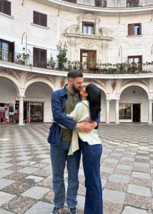 Couple embracing in a courtyard.
