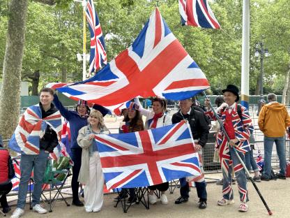 People holding Union Jack flags outside Buckingham Palace.