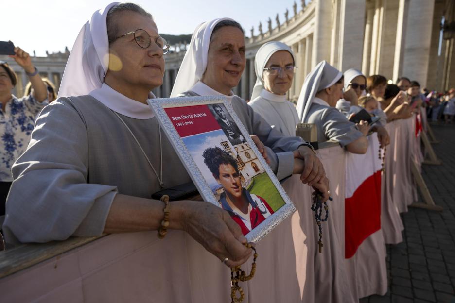 Nuns holding a picture of Carlo Acutis at his canonization.