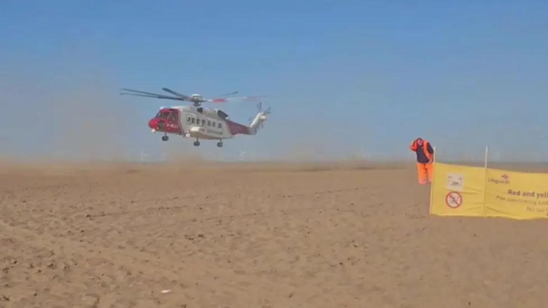 Rescue helicopter landing on beach.