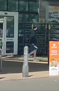Screenshot of a person walking out of a store.