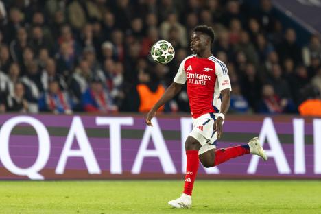 Bukayo Saka of Arsenal controlling the ball during a UEFA Champions League match.