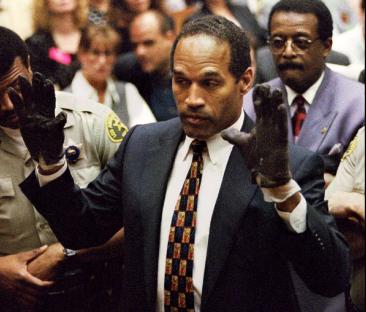 O.J. Simpson in court, wearing blood-stained gloves.