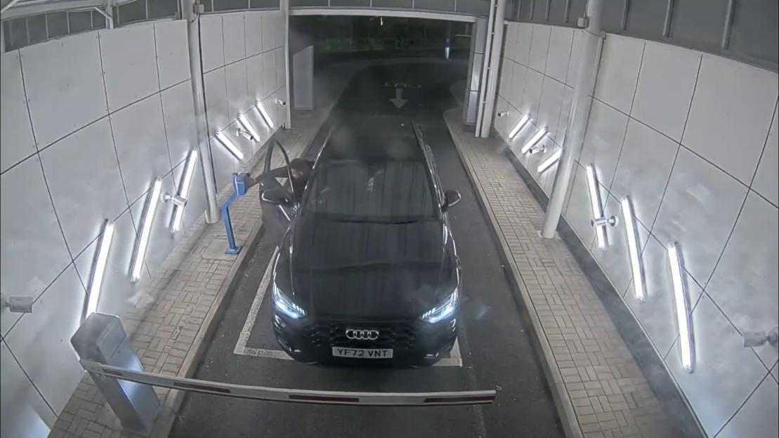 Darryl Anderson, the driver of an Audi Q5, leans out of the driver's side door at a toll booth.