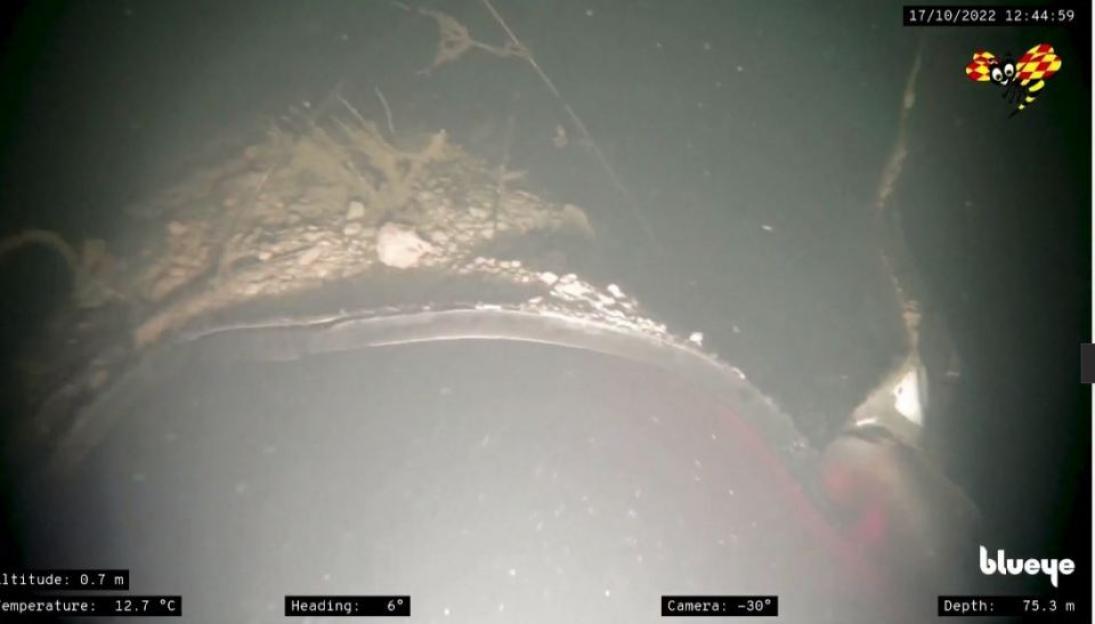 Underwater view of a damaged pipe.