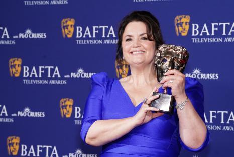 Ruth Jones holding a BAFTA award.