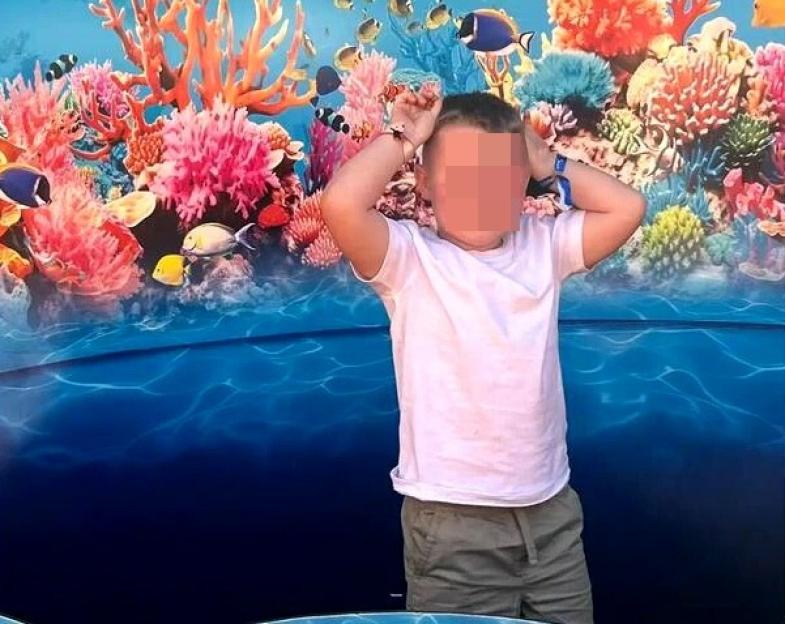 Child posing in front of a Loro Parque Immersive Coral Kingdom sign.