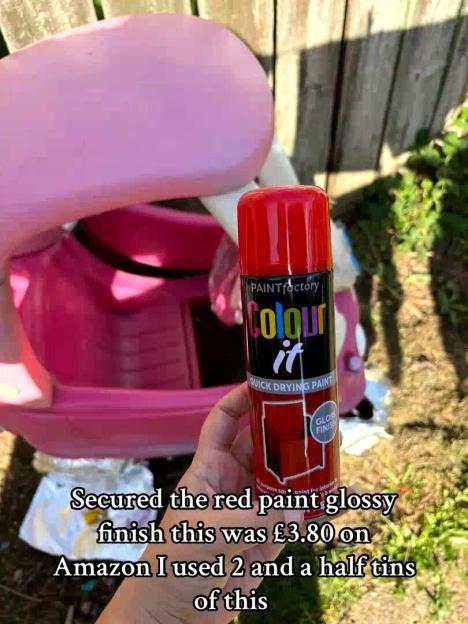 A person holding a red aerosol can of "PAINTfactory Colour it Quick Drying Paint" with a pink plastic toy car in the background.