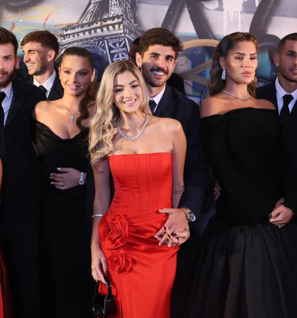 Paris Saint-Germain players Ousmane Dembele, Khvicha Kvaratskhelia, Lucas Beraldo, Lucas Hernandez, and their partners pose at the PSG Communities Foundation Gala.