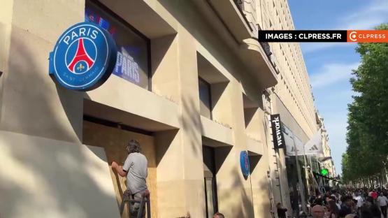 A person boarding up the Paris Saint-Germain official club shop in Paris due to looting fears.