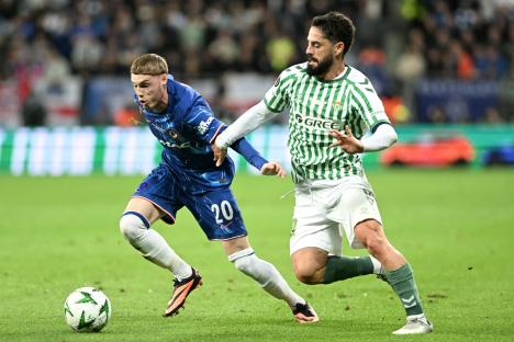 Cole Palmer of Chelsea FC and Isco of Real Betis competing for the ball during a soccer match.