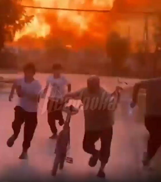 People fleeing a large fire.