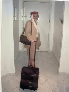 Flight attendant in uniform with a suitcase.