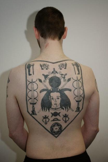 The murderer Christopher Hunnisett's back is tattooed with a shield-shaped design featuring a woman's face, swords, spears, and other symbols.